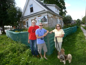 Area residents Don Muller, left, Craig Harrison, and Julie Anne Basket hope an abandoned home at 102 Wharncliffe Rd. in London will be torn down by the city. It?s unknown whether the house is on the city?s list, because the city doesn?t make those addresses public. (Morris Lamont, The London Free Press)