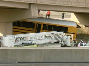 In this image made from video provided by KMGH/THEDENVERCHANNEL.COM, emergency personnel stand near the scene of a school bus that crashed into a concrete pillar in Denver,  Sunday, Sept. 11, 2016. The school bus driver was killed Sunday and several others were seriously injured after the bus veered off a roadway at Denver International Airport and crashed into a concrete pillar, police said. (KMGH/THEDENVERCHANNEL.COM via AP)