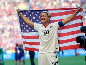 Abby Wambach holds up the U.S. flag as she celebrates after beating Japan in the FIFA Women’s World Cup in Vancouver, Sunday, July 5, 2015. (AP Photo/Elaine Thompson)