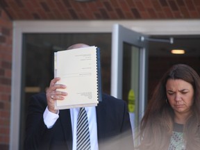 Marcello Fracassi leaves Barrie court Monday, Sept. 12, 2016, covering his face with medical records he intends to use as his defence in his drunk driving causing death trial. Geoffrey Gaston, 41, was struck and killed while he painted traffic lines in downtown Alliston June 20, 2014. (Tracy McLaughlin/Toronto Sun)