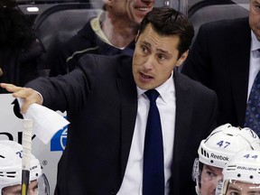 In this Feb. 24, 2013, file photo, Tampa Bay Lightning head coach Guy Boucher gives instructions from behind his bench in Pittsburgh. (AP Photo/Gene J. Puskar, File)