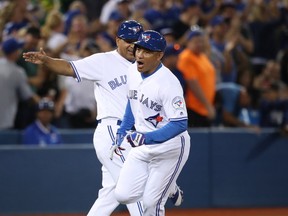Ezequiel Carrera #3 of the Toronto Blue Jays celebrates as he is congratulated by third base coach Luis Rivera #2 after hitting a pinch-hit solo home run in the eighth inning during MLB game action against the Tampa Bay Rays on September 12, 2016 at Rogers Centre in Toronto, Ontario, Canada. (Tom Szczerbowski/Getty Images)
