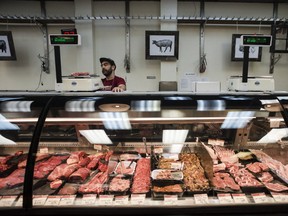 A butcher at Sanagan's Meat Locker butcher shop in Toronto weighs product to be sold on Sept. 10, 2016.(Christopher Katsarov/The Canadian Press)