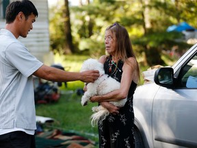 David Phung, who rescued Hailey Brouillette and her dog Sassy from her sinking car in recent floodwaters, reunites with her for the first time in Denham Springs, La., Monday, Sept. 12, 2016. An Aug. 13 rescue video shot by WAFB-TV has millions of YouTube views. It shows floodwaters swallowing Brouillette's red convertible as Phung grabbed Brouillette by her arms as the car disappeared in the murky waters. (AP Photo/Gerald Herbert)