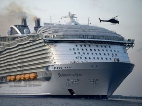 In this May 17, 2016 file photo, the world's largest passenger ship, MS Harmony of the Seas, owned by Royal Caribbean, makes her way up Southampton Water into Southampton, England. A crew member on the world's largest cruise ship has died and four others were injured when a lifeboat fell from the deck into the water during a rescue drill, the operator and officials in the French port of Marseille said Tuesday. Julien Ruas, a deputy mayor of Marseille, told the AP Tuesday that the lifeboat fell 10 meters (33 feet) or so from the fifth deck of the ship into the sea with the five crew members aboard. He identified the dead crew member as a 42-year-old Filipino.  (Andrew Matthews/PA via AP, file)
