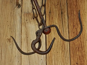 Hooks for hanging meat on the background of wooden boards. (Getty Images)