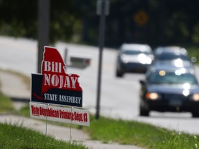 A sign supporting deceased Assemblyman Bill Nojay, who was seeking re-election, sits on Monroe Avenue near French Road on Tuesday, Sept. 13, 2016, in Pittsford, N.Y. (Tina MacIntyre-Yee /Democrat & Chronicle via AP)