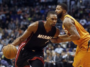 In this Jan. 8, 2016, file photo, Miami Heat forward Chris Bosh drives on Phoenix Suns forward Markieff Morris during an NBA basketball game in Phoenix. (AP Photo/Rick Scuteri, File)