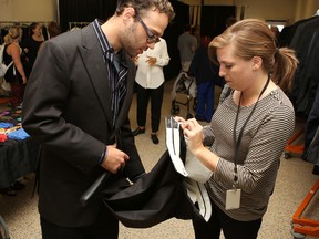 Danielle Quenneville helps Brett Kinkley-Dale, 22, pick a suit jacket off the rack at the KEYS and Dress for Success Suit Up project on Wednesday. (Elliot Ferguson/The Whig-Standard)