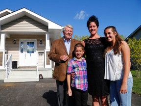 Luke Hendry/The Intelligencer
Habitat for Humanity's Bob Clute joins Anita Ramji and her children, Rafi and Liberty, outside the trio's new home in Belleville Wednesday. "It's a new beginning for us," Ramji said. It's the fourth home presented this year to a local family by Habitat's Prince Edward-Hastings branch.