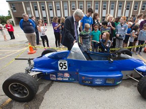 Waterloo-based Formula 1600 race car driver Amy Castell, 21, shows her race car to Transport Minister and former astronaut Marc Garneau, Arthur Ford Public School pupils Malachy Elliott, 10, and Valeria Campos, 8, and Let's Talk Science volunteer David Pipher, as they take part in Energy4Travel, a Canada-wide research project that uses students' transportation data to calculate their personal consumption led by Let's Talk Science, at the Westmount school in London, Ont. on Wednesday September 14, 2016. Castell was joined by Garneau for a Q and A session before students took part in science-based transportation activities, such as creating small rockets, in the schoolyard. (CRAIG GLOVER, The London Free Press)