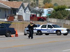 A Cheyenne police officer tapes off North College Drive after a shooting at Heritage Court Apartments Wednesday, Sept. 14, 2016 in northeast Cheyenne, Wyo. A 77-year-old man living at a senior citizen apartment complex shot three people at the complex Wednesday, killing one of them, and then killed himself nearby as officers closed in on him, police said. (Blaine McCartney/The Wyoming Tribune Eagle via AP)