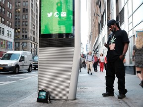 A man uses one of the new Wi-Fi kiosks that offer free web surfing, phone calls and a charging station on August 24, 2016 in New York City. The LinkNYC terminals, which number around 300 in Manhattan, have become especially popular with both the homeless and panhandlers. The free kiosks were installed to replace obsolete pay phones around Manhattan. (Photo by Spencer Platt/Getty Images)