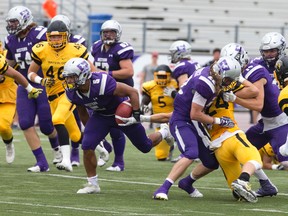 The Western Mustangs formidable running game is led by Alex Taylor, carrying the ball through a hole in the Waterloo Warriors defence during an OUA football game in London on Sept. 10. (Craig Glover/Postmedia Network)