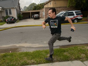 Writer and actor Gideon Hodge runs towards his burning home in New Orleans, La., Thursday, Sept. 15, 2016. Hodge then rushed into the structure – past firefighters yelling at him to stop – to grab his laptop, which he said had two completed novels on it. (Matthew Hinton/The Advocate via AP)