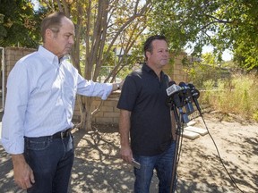 Former NASCAR racer Robby Gordon, right, with family friend Steve Nichols, left, makes a statement to members of the media gathered outside his home in Orange, Calif., on Sept. 15, 2016. (AP Photo/Damian Dovarganes)