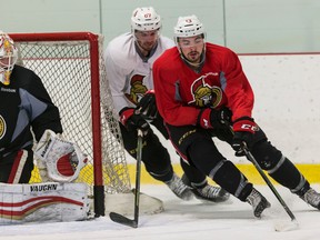 Nick Paul (front) fends off the check of Ben Harpur beside netminder Chris Driedger during the Senators rookie camp on Thursday, Sept. 15, 2016. (Errol McGihon/Postmedia)