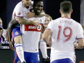 Toronto FC's Sebastian Giovinco (left) jumps on the back of Jozy Altidore (centre) and Daniel Lovitz (19) joins in the celebration after Altidore scored the game-winning goal against Orlando City in the second half of an MLS soccer game Aug. 24, 2016, in Orlando, Fla. Toronto FC won 2-1. (JOHN RAOUX/AP)