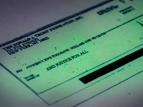 This photo made in the Associated Press Washington bureau on Thursday, Sept. 15, 2016 shows a copy of a cheque provided by the New York state attorney general that shows a payment of $25,000 from the Donald J. Trump Foundation to And Justice For All signed by Donald J. Trump. The $25,000 cheque was sent from his personal foundation to a political committee supporting Florida Attorney General Pam Bondi. Charities are barred from engaging in political activities. Trump’s campaign contends that the 2013 cheque from the Trump Foundation was mistakenly issued following a series of clerical errors and that Trump intended to use personal funds. (AP Photo/J. David Ake)