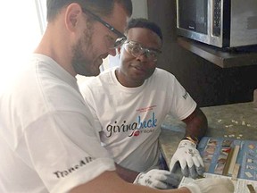Oyekunle Olaoye and Ilshat Khasanov from SNC Lavalin participate in the United Way of Sarnia-Lambton Day of Caring to help launch the 2016 fundraising campaign. Olaoye and Khasanov are installing a backsplash at Sarnia and District Association for Community Living’s facilities, while other volunteers from SNC Lavalin and Imperial stained a deck and provided other general maintenance requirements at the group home. United Way photo