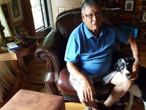 Residential school survivor Michael Cachagee at his home in Goulais River with his dog, Stormy.