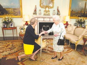 Her purse present as always, Queen Elizabeth II welcomes Theresa May at the start of the audience where she invited the former British home secretary to become prime minister in July.