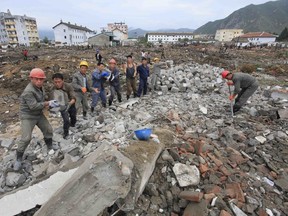 Workers recover cement blocks from flood-damaged areas in Onsong, North Hamgyong Province, North Korea, Friday, Sept. 16, 2016. North Korean soldiers and relief teams rushed to clear roads and railway tracks, build shelters and provide food and sanitation Friday to tens of thousands of residents in a remote part of the country near the Chinese border that was devastated by heavy downpours and flash-floods when a typhoon pounded their villages last week. (AP Photo/Kim Kwang Hyon)