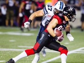 Redblacks receiver Greg Ellingson (82) carries the ball upfield while Argonauts' Cory Greenwood (27) pursues during CFL action at TD Place Arena in Ottawa on July 31, 2016. (Darren Brown/Postmedia)
