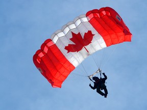 A member of the SkyHawks, the Canadian Armed Forces parachute demonstration team, shows the flag at Airshow London 2016 in the skies over London International Airport Friday. (MORRIS LAMONT, The London Free Press)