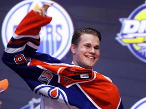 Jesse Puljujarvi puts on an Edmonton Oilers jersey after being selected fourth overall at the 2016 NHL Draft on June 24, 2016 in Buffalo, New York.