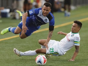 Edmonton's Shawn Nicklaw, left, and New York's David Diosa collide during NASL soccer play between FC Edmonton and the New York Cosmos at Clarke Stadium in Edmonton, on Wednesday, July 27, 2016.