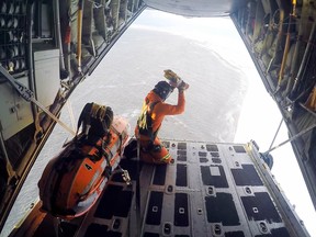 An unidentified search and rescue technician from Trenton's 424 Squadron drops gear to hunters stranded on Bylot Island in Nunavut.