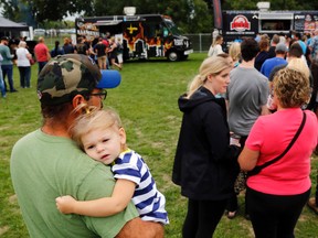 Trenton's Jeff Poot holds his 1.5-year-old daughter, Carly, while standing in line at the Food Trucks United Saturday in Trenton's Centennial Park. It raised funds for the United Way of Quinte, which this year aims to raise $2,115,600.