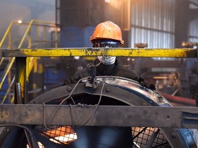 A picture taken September 14, 2016 shows a worker at a steel factory producing concrete reinforcing steel, in Abidjan. (AFP PHOTO / ISSOUF SANOGOISSOUF SANOGO/AFP/Getty Images)