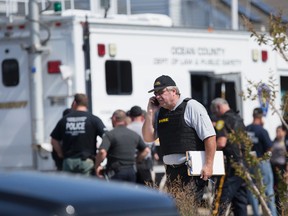 Police gather at a command center in Seaside Park, N.J., on Saturday, Sept. 17, 2016, during an investigation of a pipe bomb which exploded before a charity race to benefit Marines and sailors. No injuries were reported. (Peter Ackerman/The Asbury Park Press via AP)