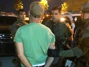 This photo provided by the Los Angeles County Sheriff's Department shows a suspect taken into custody after an hours-long standoff after an armed man barricaded himself aboard an Amtrak train at the Metrolink station in the Chatsworth area of Los Angeles in the early morning hours of Saturday, Sept. 17, 2016. Nearly 200 passengers and crew on the train bound for San Diego were evacuated Friday night after several reported seeing a man with a weapon. (AP Photo/Los Angeles County Sheriff's Department via AP)