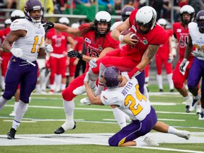 Jesse Mills of the Carleton Ravens tries to get past Scott Hutter of the Laurier Golden Hawks during university football action in Ottawa on Saturday, Sept. 17, 2016. (Ashley Fraser/Postmedia)