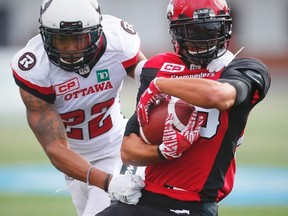 Stampeders' Anthony Parker (right) is tackled by Jeff Richards of the Redblacks, who was called for unnecessary roughness on the play, during CFL action in Calgary on Saturday, Sept. 17, 2016. (Al Charest/Postmedia)