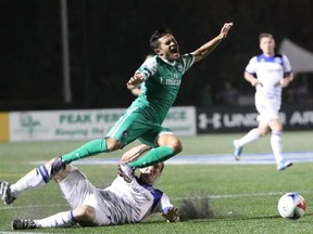 FC Edmonton captain Albert Watson trips New York Cosmos midfielder Andres Flores in a North American Soccer League game Saturday in Hempstead, NY. The game finished in a scoreless tie.