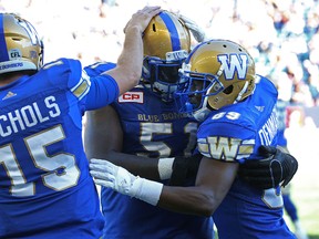 Winnipeg Blue Bombers WR Clarence Denmark (right) celebrates his touchdown catch against the Toronto Argonauts during CFL action in Winnipeg with QB Matt Nichols (left) and OL Jemarcus Hardrick on Sat., Sept. 17, 2016. Kevin King/Winnipeg Sun/Postmedia Network