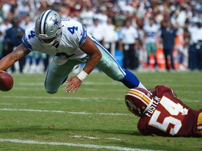 Cowboys quarterback Dak Prescott (4) dives into the end zone for a touchdown as Redskins inside linebacker Mason Foster (54) hangs on during second half NFL action in Landover, Md., on Sunday, Sept. 18, 2016. (Nick Wass/AP Photo)