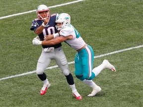 Dolphins linebacker Kiko Alonso (right) hits Patriots quarterback Jimmy Garoppolo (10) after he threw a pass during first half NFL action in Foxborough, Mass., on Sunday, Sept. 18, 2016. Garoppolo was injured on the play and did not return. (Stew Milne/AP Photo)
