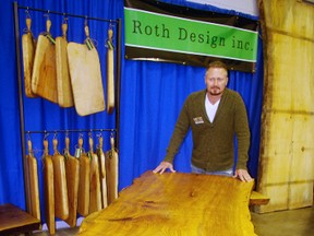 Andy Roth of Roth Design shows off a dining room table made from a slab of white ash at the Woodstock Woodworking Show last year. New vendors and an antique car show are features of this year's event coming up Sept. 30 to Oct. 2. (HEATHER RIVERS/WOODSTOCK SENTINEL-REVIEW FILE PHOTO)