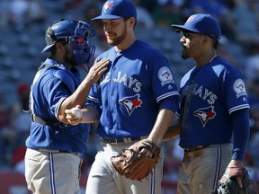 Toronto Blue Jays relief pitcher Danny Barnes, center, gets a pat on the shoulder from catcher Dioner Navarro after he is taken out of a baseball game. (AP Photo/Christine Cotter)