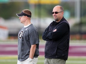 Brock Sunderland (L), Assistant General Manager and Marcel Desjardins, General Manager of the Ottawa RedBlacks during morning practice in Ottawa, August 26, 2015. Time 12:24 (Jean Levac/ Ottawa Citizen)