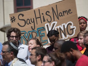 Demonstrator Ciara Humphrey, right, holds a sign during a rally for Tyre King, the 13-year-old Ohio boy who was fatally shot by Columbus police, Monday, Sept. 19, 2016, outside City Hall in Columbus, Ohio. King was shot after being confronted by police investigating a robbery. Police claim King had a BB gun that looked like a real firearm. (AP Photo/John Minchillo)