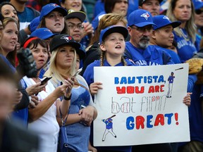 A fan holds a sign that reads "Bautista You Are Bat Flippin' Great!" in support of Toronto Blue Jays right fielder Jose Bautista during batting practice before a baseball game against the Seattle Mariners, Sept. 19, 2016, in Seattle. (TED S. WARREN/AP)
