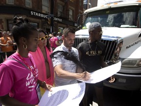 Mathieu Chantelois signs a list of demands from the Black Lives Matters movement as they stage a sit-in at the annual Pride Parade in Toronto on  July 3, 2016. (Mark Blinch/The Canadian Press)