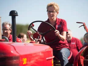Premier Kathleen Wynne takes part in a plowing competition during the International Plowing Match in Harriston, Ont. on Tuesday, September 20, 2016. Tuesday, Sept. 20, 2016. (THE CANADIAN PRESS/Hannah Yoon)