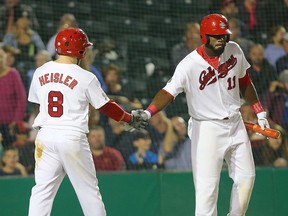 Winnipeg Goldeyes designated hitter Adam Heisler (l) is congratulated by centre fielder Reggie Abercrombie after scoring a run against the Wichita Wingnuts during game 2 of the American Association championship in Winnipeg, Man. Thursday September 15, 2016.